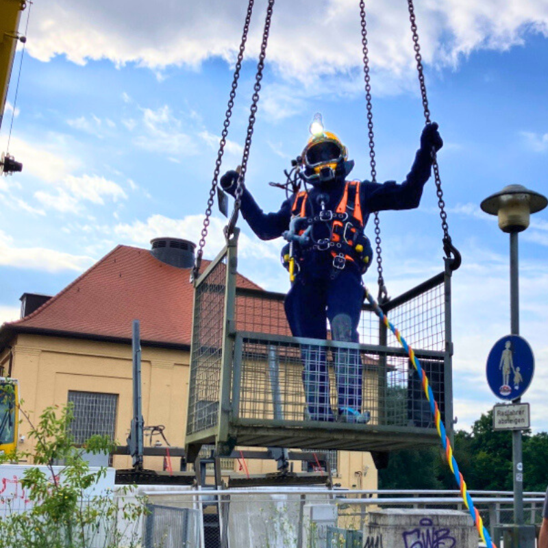 Ein Taucher wird beim Neckarwerk ins Wasser gelassen