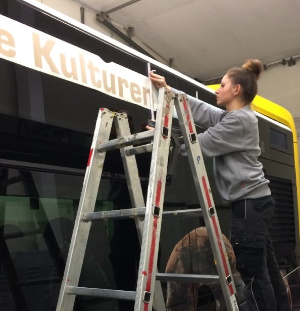 Bus wird von Werbetechnikerin beklebt