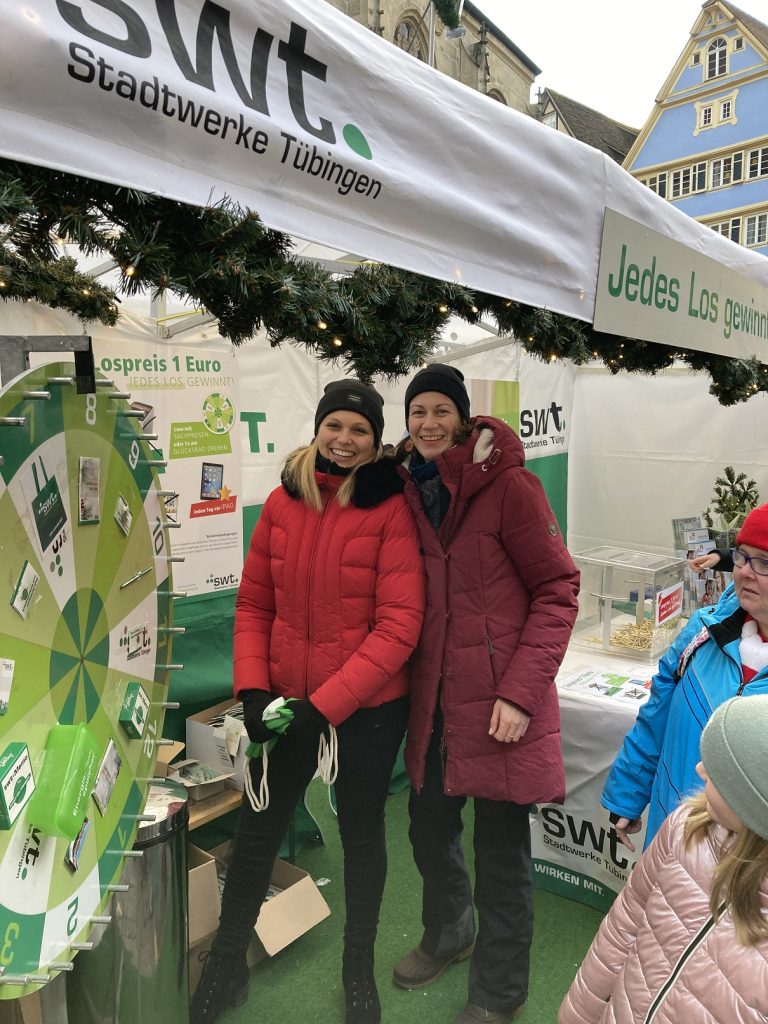 swt-Stand auf dem Tübinger Weihnachtsmarkt mit Tombola und Glücksrad, Linda Löffler und Kathi Brielmann