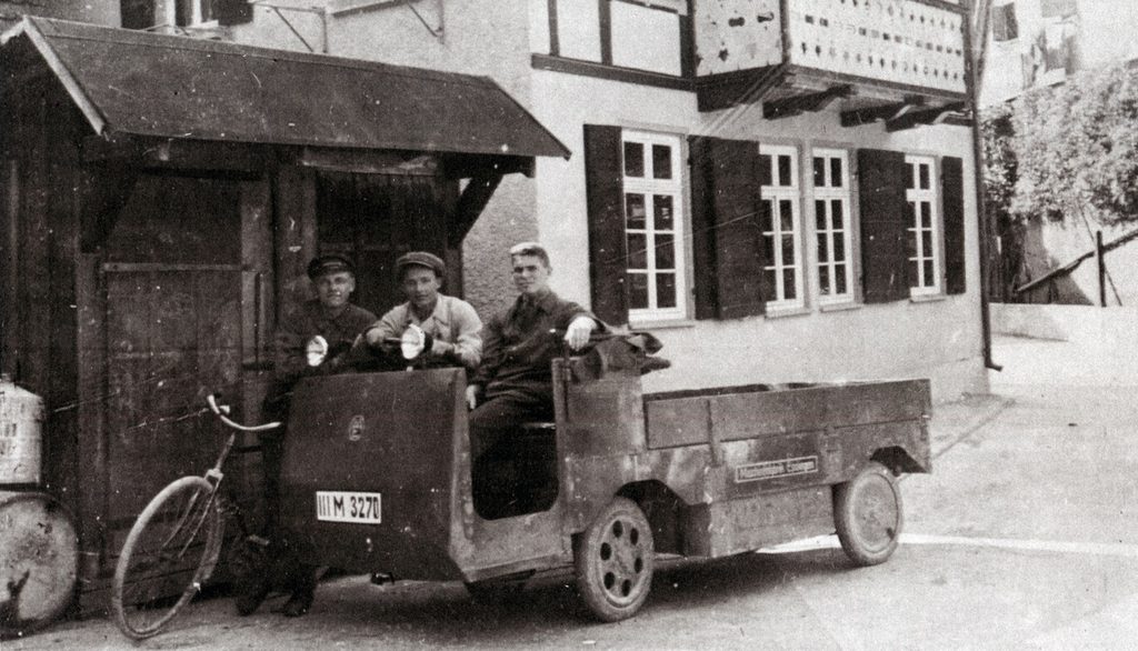 Elektrowagen der Stadtwerke in der Altstadt, ein Monteur mit Fahrrad, 2 im E-Wagen