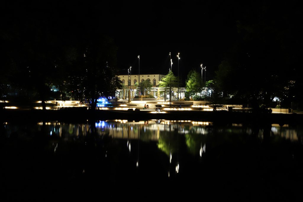 "Licht nach Bedarf" im Anlagenpark: Blick übern See zum Hauptbahnhof 